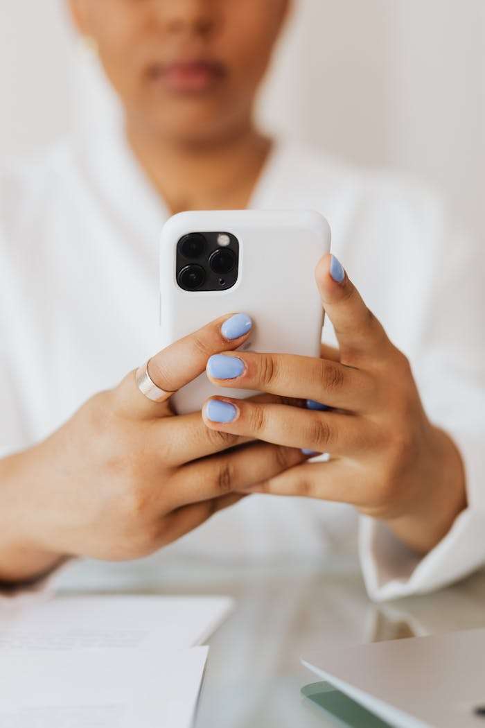 services-01 Close-up view of woman holding a smartphone indoors, showcasing modern technology.